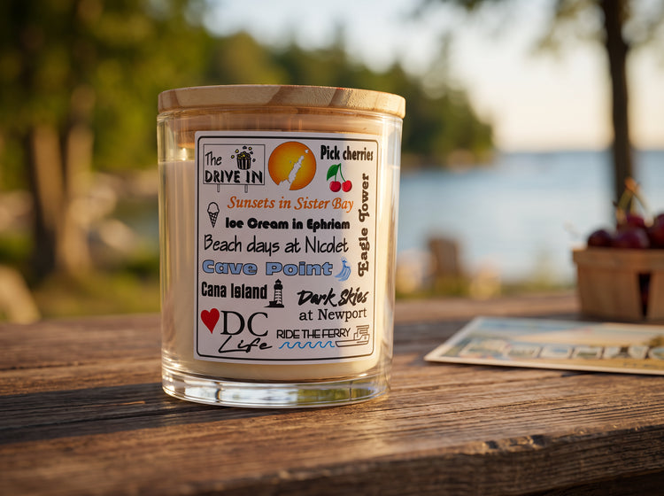 DC Life candle — golden-hour light on a weathered wood table with a blurred shoreline behind