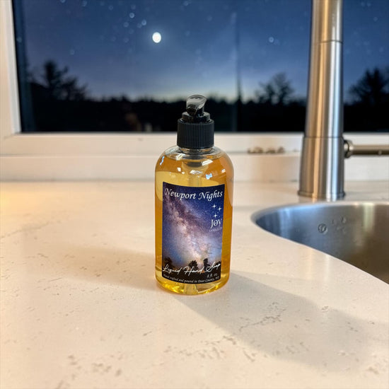 Newport Nights Liquid Hand Soap on a kitchen counter by a window with a moonlit night sky